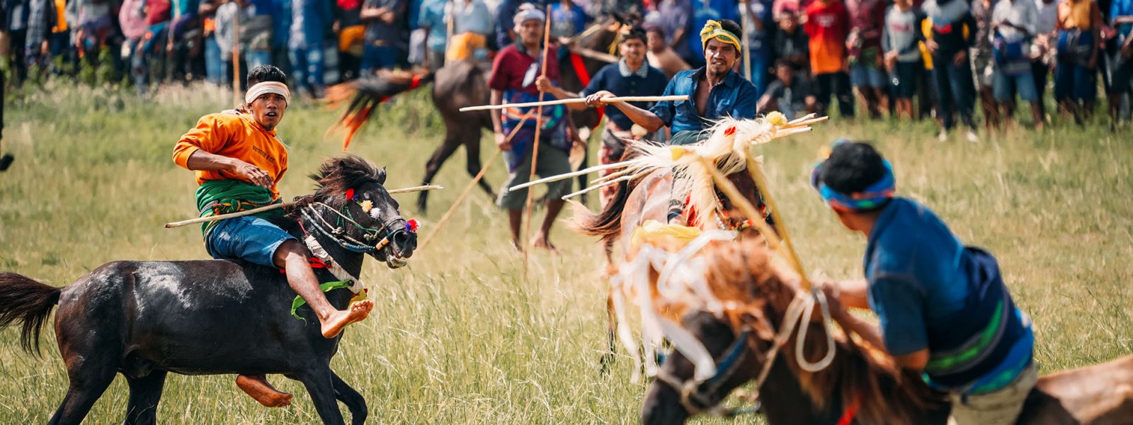 Pasola Festival Reiter auf Sumba reiten aufeinander zu.