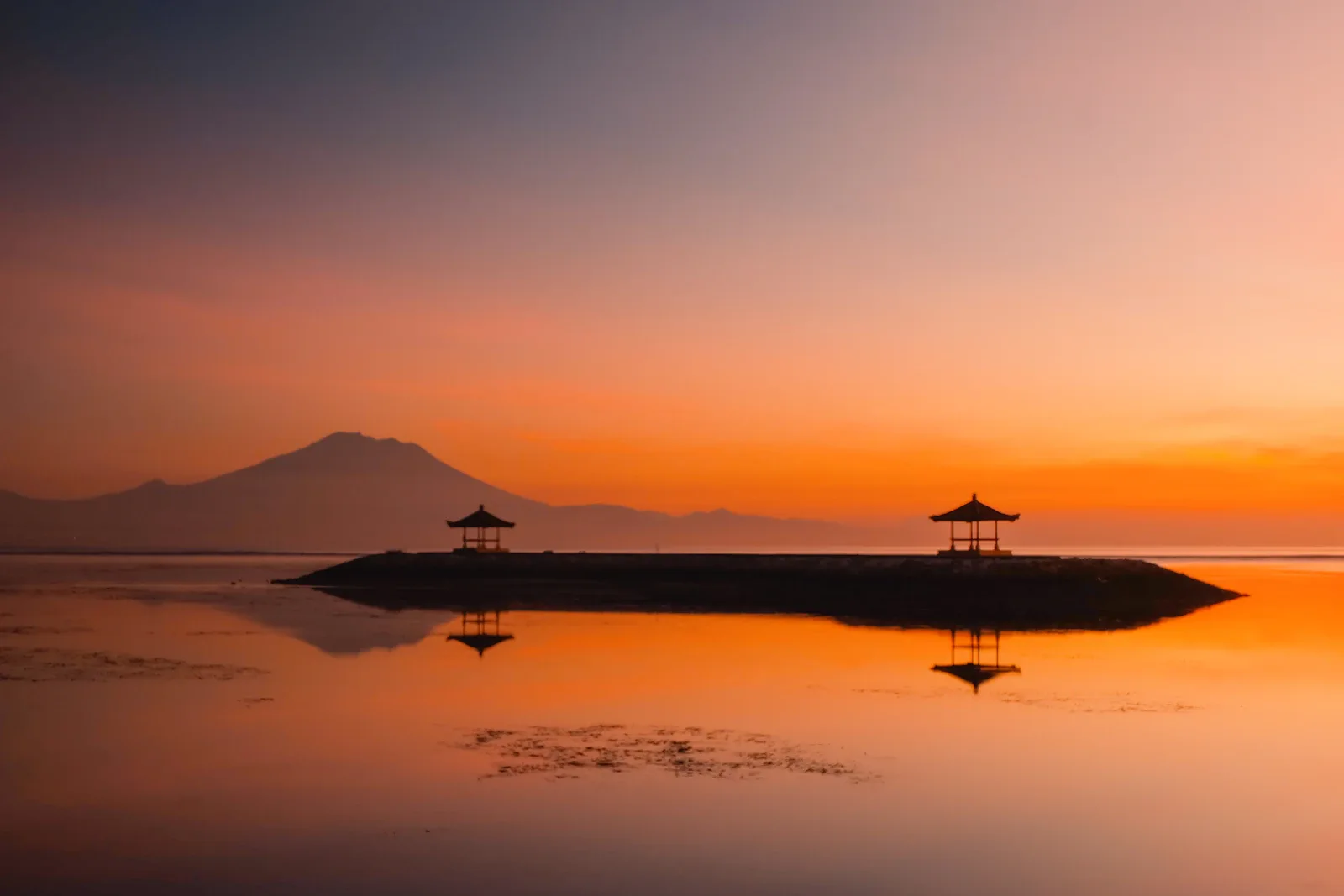 Ruhiger Strand von Sanur am Morgen mit flachem Wasser und traditionellen Booten, ideal für Bali mit Kindern Reise