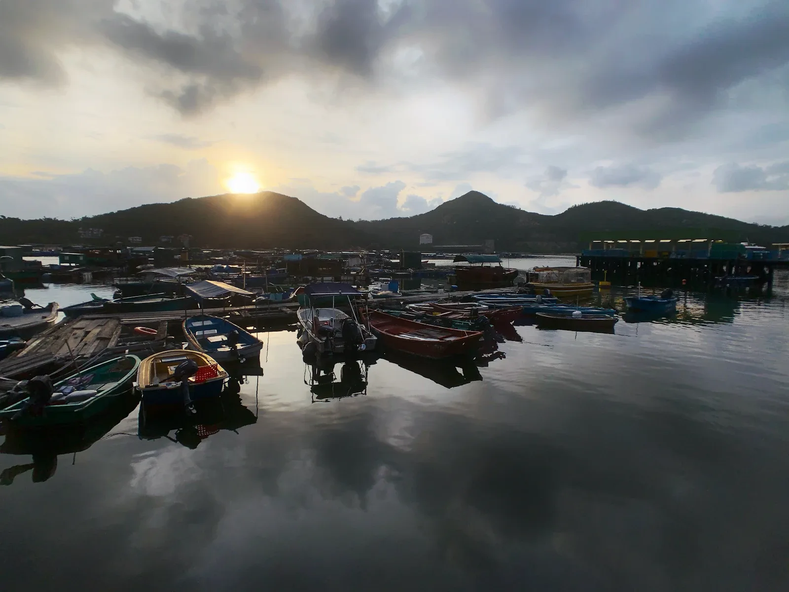 Traditionelle Holzboote im Hafen von Labuan Bajo bei Sonnenuntergang, Ausgangspunkt für Flores Rundreisen nach Komodo
