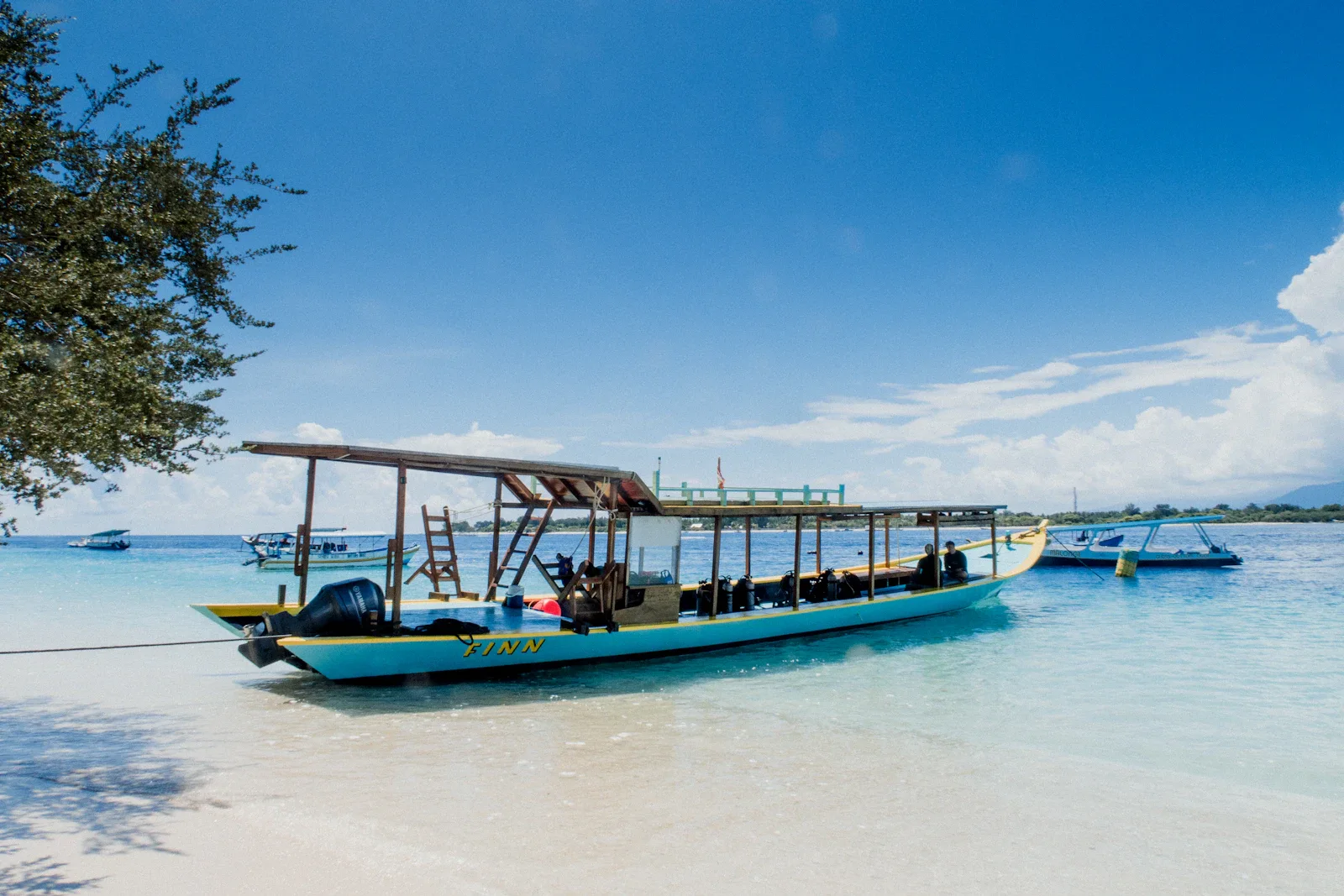 Fahrrad auf sandiger Küstenstraße vor türkisfarbenem Meer, Gili Inseln, Indonesien Individualreise