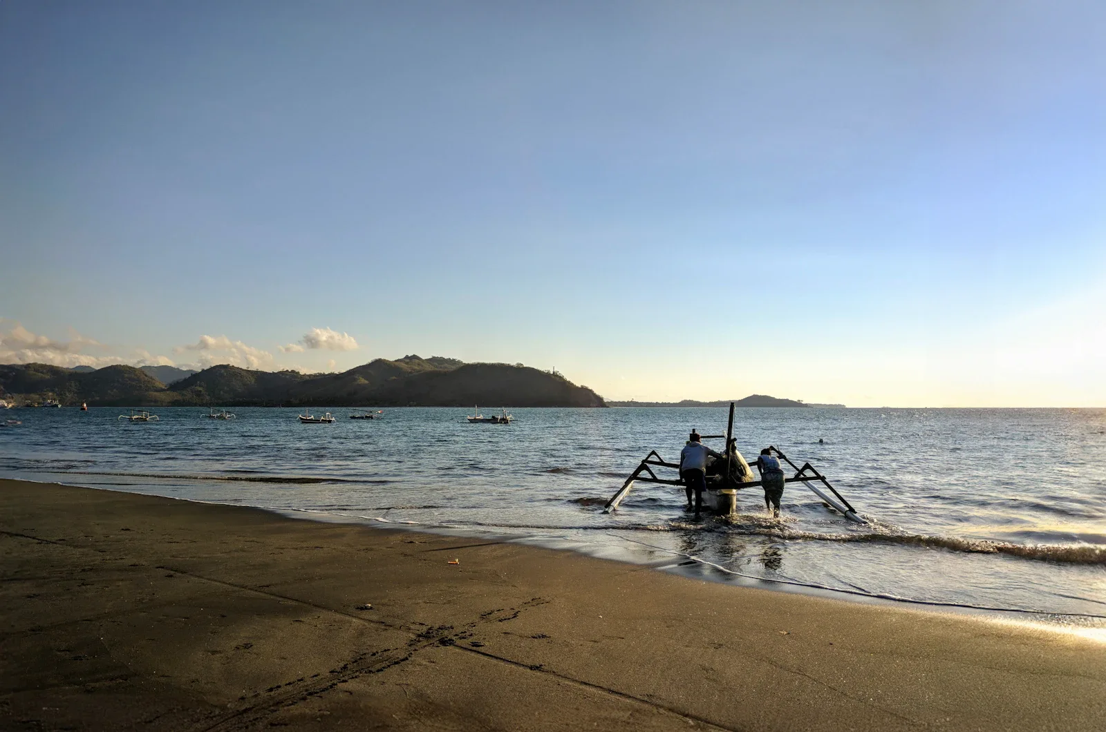 Traditionelles Holzboot am Strand bei Sonnenuntergang, Lombok Südküste, Indonesien Individualreise