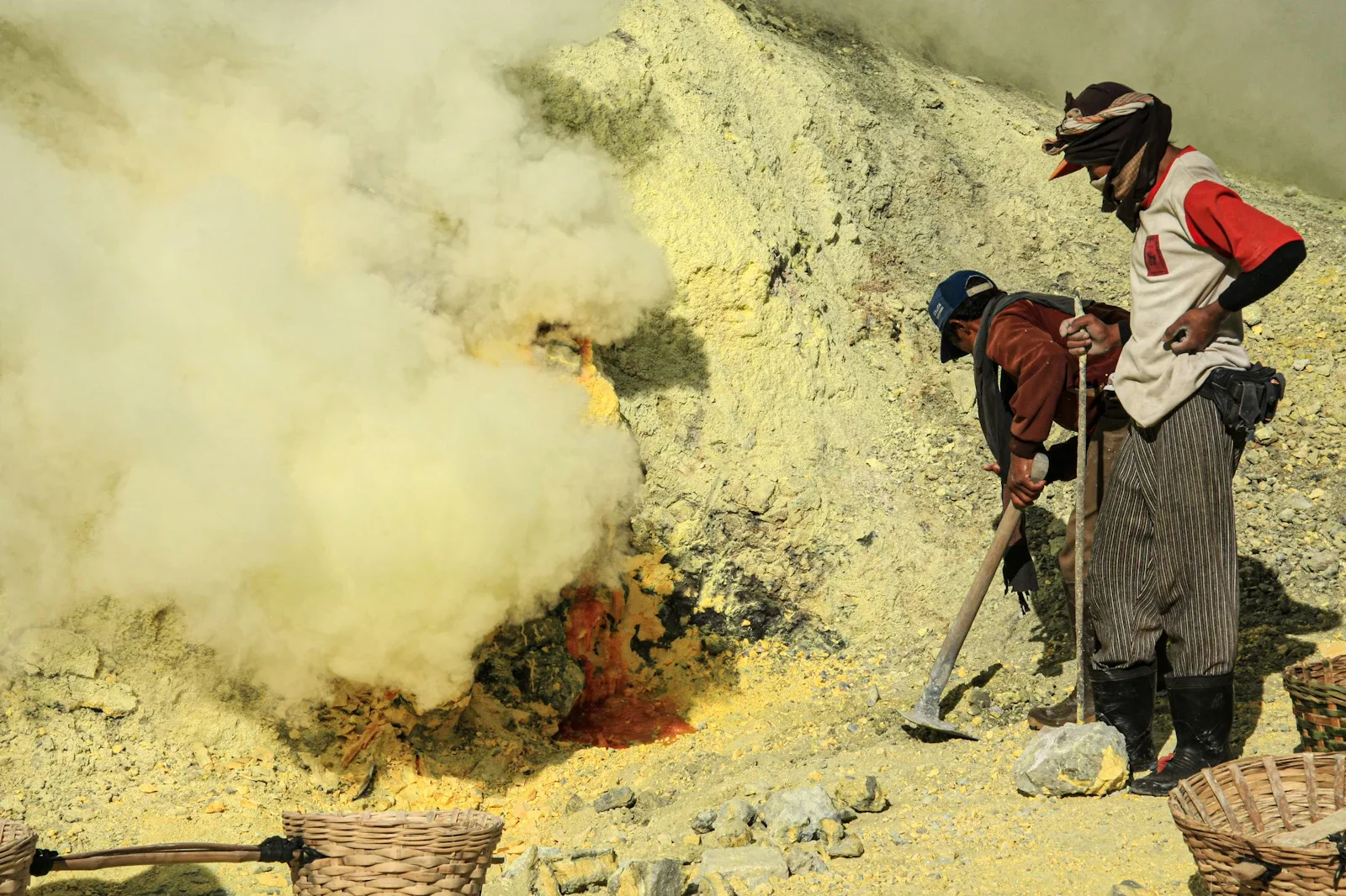 Schwefelträger mit gelben Schwefelblöcken im Ijen-Krater, Ostjava, traditionelle Arbeit am Vulkan in Indonesien